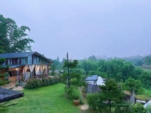 a house on a hill with a green yard at ภูเก็บตะวัน in Khao Kho