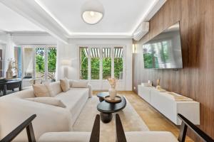 un salon avec un canapé blanc et une table dans l'établissement Luxueux, spacieux et tout équipé à 5 min du port, à Nice