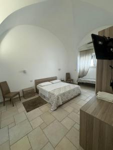 Un dormitorio con una cama y un televisor de pantalla plana. en Augustus B&B, en Terlizzi