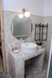 a bathroom with a white sink and a mirror at Destine Holiday Bungalow in Galle