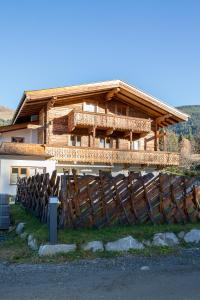 a large wooden house with a fence in front of it at Apartment Steger in Mittersill