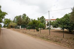 an empty road with a fence and a house at Villa del Lupo in Santa Maria la Palma