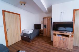 un piccolo soggiorno con una TV a schermo piatto di Guest House Babilon a Prijedor