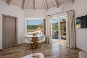 a living room with a table and chairs and a large window at Ilios Villa Private Pool by ILIOS Georgioupoli in Georgioupoli