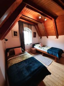 an attic room with two beds and a window at Holiday home Szentantalfa - Balaton 20230 in Szentantalfa