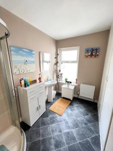 um banheiro com chuveiro, pia e vaso sanitário em Station View Portrush em Portrush mais 19 fotografias