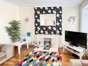 uma sala de estar com lareira e TV em Station View Portrush em Portrush