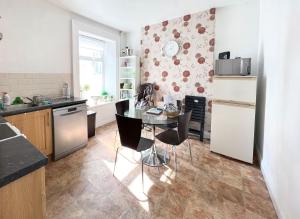 a kitchen with a table and chairs in a room at Station View Portrush in Portrush