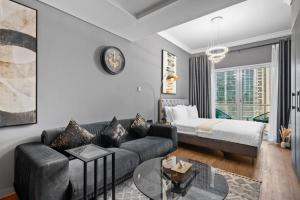 a living room with a couch and a bed at Luxury studio at JLT near metro in Dubai