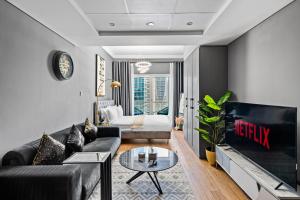 a living room with a couch and a tv at Luxury studio at JLT near metro in Dubai