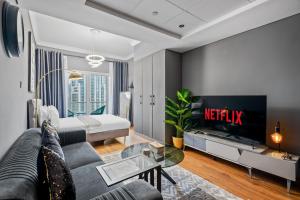 a living room with a couch and a tv at Luxury studio at JLT near metro in Dubai