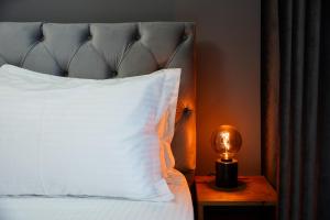 a bed with a white pillow and a light on a table at Luxury studio at JLT near metro in Dubai