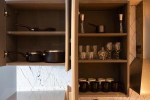 a kitchen with shelves with pots and pans at Luxury studio at JLT near metro in Dubai