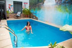 a woman is standing in the water in a swimming pool at Hotel Sueño Tropical in Tarapoto