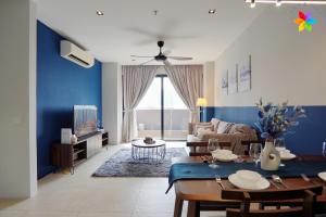 a living room with a table and a blue wall at Lumi Tropicana By LilyandLoft in Petaling Jaya