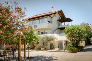 a large white building with trees in front of it at Villa Vivari Suites in Vivari