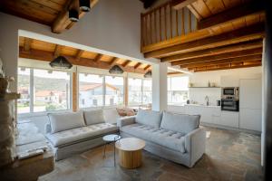 a living room with two couches and a kitchen at Villa Vivari Suites in Vivari