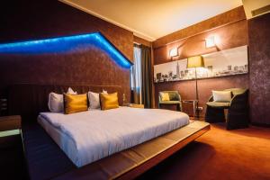 a hotel room with a bed with yellow pillows at Plaza V Executive Hotel in Târgu-Mureş