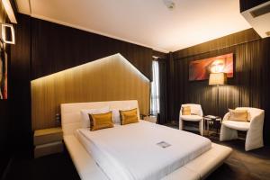a hotel room with a bed and a chair at Plaza V Executive Hotel in Târgu-Mureş +78 photos