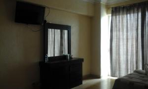 a bedroom with a mirror and a dresser with a television at Hotel RRU Diamante in Acapulco