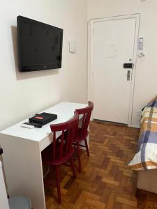 een kamer met een tafel en twee stoelen en een tv aan de muur bij Lindo Studio Flamengo in Rio de Janeiro