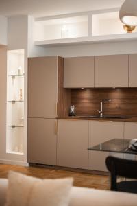 - une cuisine avec des placards blancs, un évier et une table dans l'établissement Luxueux, spacieux et tout équipé à 5 min du port, à Nice