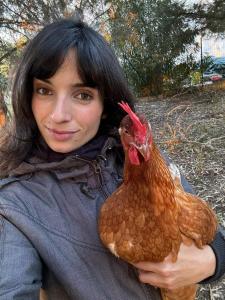 a woman holding a chicken in her arms at Villa del Lupo in Santa Maria la Palma