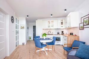 a kitchen and living room with a table and chairs at Blue Sun Apartament Słoneczny in Kołobrzeg