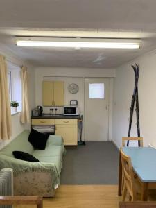 a living room with a couch and a kitchen at Sleeping Giant outdoor adventure flat in Pen-y-cae
