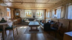 una sala de estar con un sofá y una mesa en Ferienhaus Judie, en Lechbruck