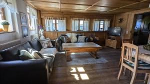 una sala de estar con un sofá y una mesa en Ferienhaus Judie, en Lechbruck