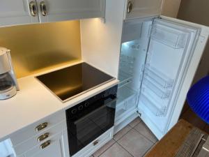 cocina con fogones y nevera vacía en Ferienhaus Judie, en Lechbruck