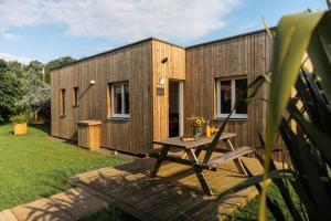 a wooden house with a picnic table in the yard at Chais de L'Epinay in Le Bignon