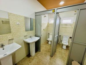 a bathroom with two sinks and a shower and a toilet at Havelock City Hostel, Colombo in Colombo