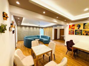 uma sala de estar com um sofá azul e mesas e cadeiras em Havelock City Hostel, Colombo em Colombo
