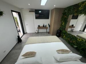 a bedroom with a large white bed with two pillows at Suite Romantique Reve d Amazonie option espace Spa complet en supplément in Les Mages