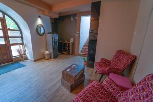 a living room with two chairs and a refrigerator at Guest House Babilon in Prijedor