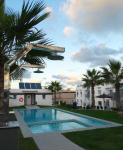 a swimming pool in a yard with palm trees and a building at Apartment Escorpiones in Torrevieja
