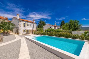 a swimming pool in front of a house at Holiday house Rural home Frane in Kornić