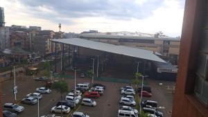 a parking lot with cars parked in front of a building at Gany Home Vibes - Comfy 1-bedroom apartment in Nairobi with Parking and Netflix - TRM drive in Nairobi