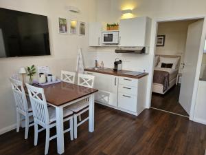 a small kitchen with a table and a dining room at List Five - Your British Guesthouse in Stuttgart