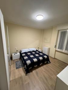 a bedroom with a bed with a blue and white blanket at Casa Facetti presso HOTEL KRISTALL in Diano Marina