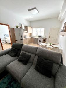 a living room with a couch and a kitchen at Casa El Verano in Puerto de Mogán