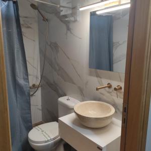 a bathroom with a bowl sink and a toilet at Maria's Apartment Nafplio in Nafplio +17 photos