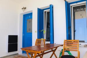 a wooden table and chairs in front of a blue door at Ateni House in Agios Petros