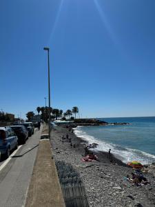 a beach with people laying on the sand and the water at Casa Facetti presso HOTEL KRISTALL in Diano Marina