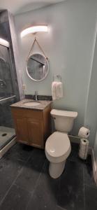 Un baño con inodoro, lavabo y espejo. en Oakdale Area Nice Location, en Portland