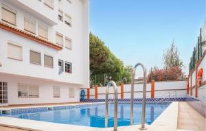 a swimming pool in front of a building at Lovely Apartment In Matalascañas in Matalascañas
