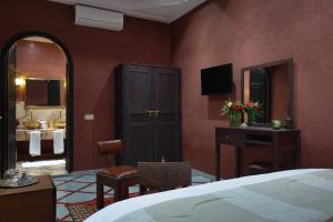 una camera da letto con un letto e un bagno con un lavandino di Alrashid Marrakech Boutique Hotel & SPA a Marrakech
