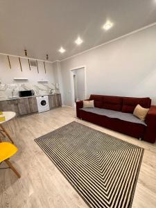 a living room with a couch and a kitchen at Квартира в новом ЖК Абай in Kokshetau
